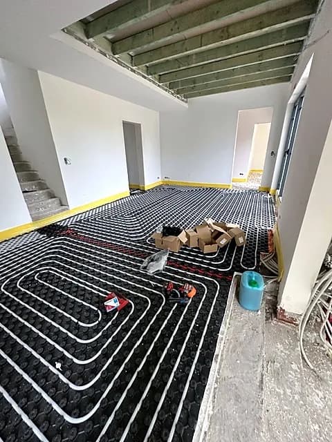 Grande pièce de vie avec chauffage par le sol en boucles, escalier au fond