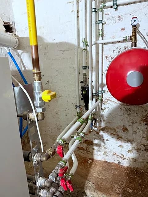Tuyauteries, vannes et manomètre dans une chaufferie